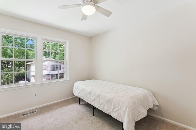 carpeted bedroom featuring baseboards and a ceiling fan