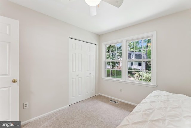 unfurnished bedroom featuring carpet floors, baseboards, a closet, and ceiling fan