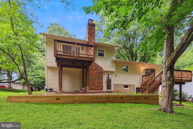 back of house featuring a chimney, a balcony, and a yard