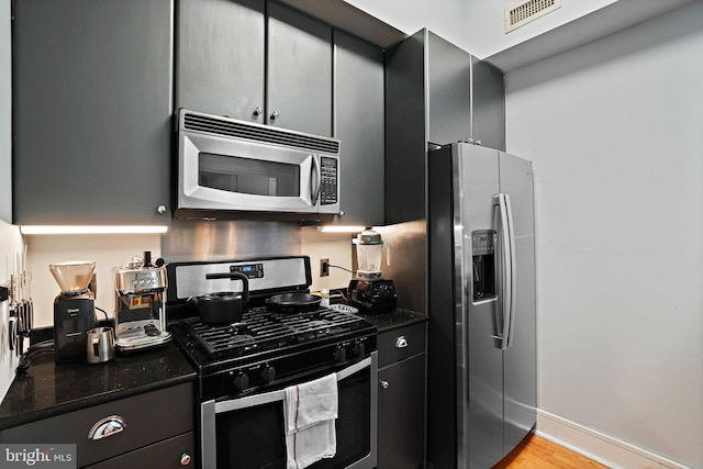809 6th St NW Unit 63, Washington, DC 20001 - kitchen featuring stainless steel appliances, light wood-style floors, and dark stone counters