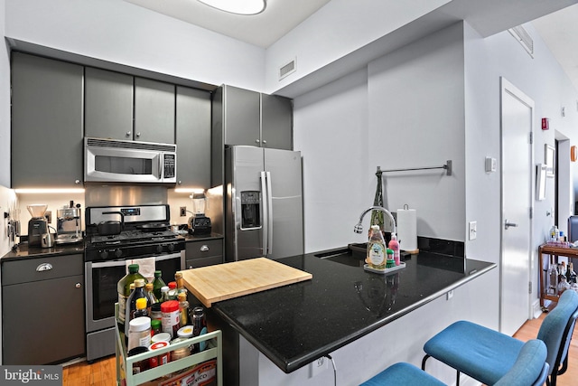 809 6th St NW Unit 63, Washington, DC 20001 - kitchen featuring stainless steel appliances, dark countertops, gray cabinetry, and light wood-type flooring