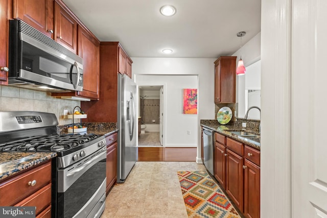 400 Cameron Station Blvd Unit 417, Alexandria, VA 22304 - kitchen featuring appliances with stainless steel finishes, a sink, tasteful backsplash, dark stone counters, and pendant lighting
