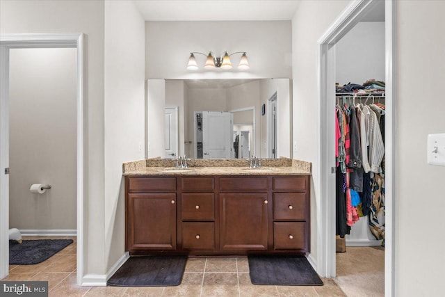 2121 River Heritage Blvd, Dumfries, VA 22026 - bathroom featuring double vanity, tile patterned floors, a spacious closet, and baseboards