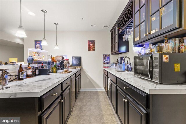 2121 River Heritage Blvd, Dumfries, VA 22026 - kitchen featuring black microwave, a sink, glass insert cabinets, pendant lighting, and baseboards