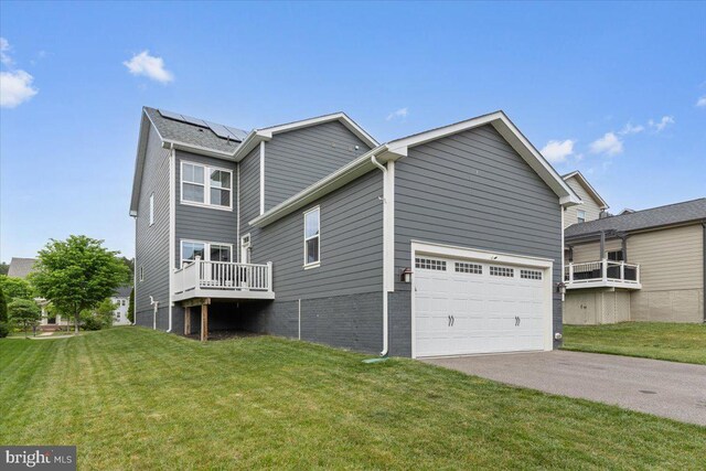2121 River Heritage Blvd, Dumfries, VA 22026 - back of property with a yard, driveway, solar panels, and a garage