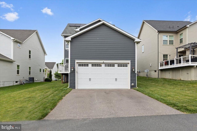 2121 River Heritage Blvd, Dumfries, VA 22026 - view of front facade with asphalt driveway, a front lawn, roof mounted solar panels, and a garage