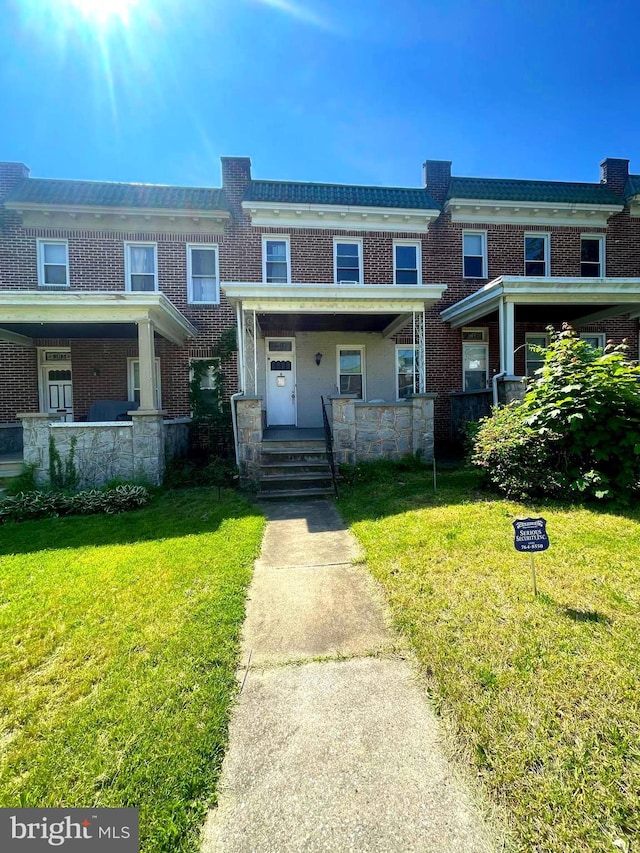 view of property with a front yard and brick siding