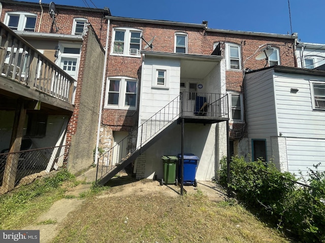 back of house with brick siding and fence