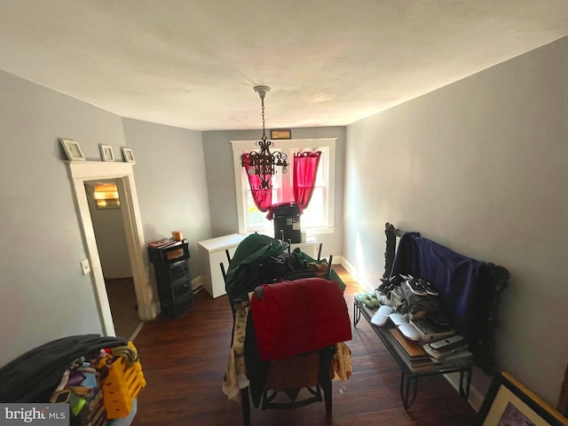 dining area featuring wood finished floors, a chandelier, and baseboards