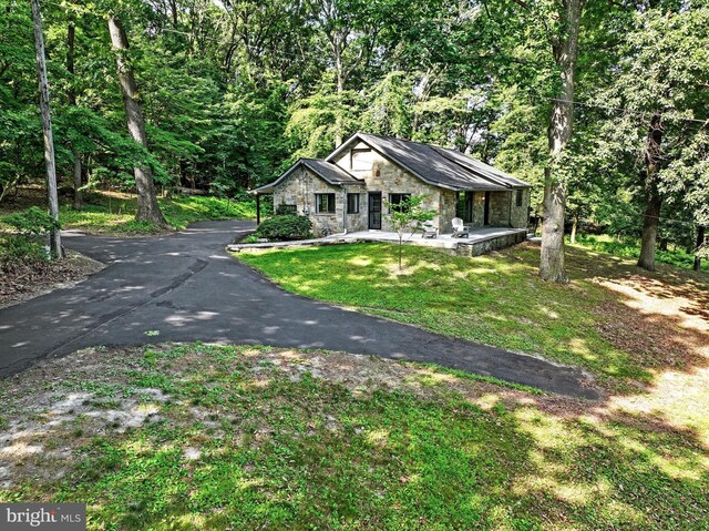 2570 Mount Zion Rd, York, PA 17406 - view of front facade featuring stone siding, a front yard, a wooded view, and driveway