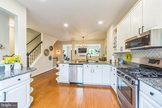 517 Bullock Unit 13, Conshohocken, PA 19428 - kitchen featuring stainless steel appliances, a peninsula, a sink, white cabinets, and light wood-style floors