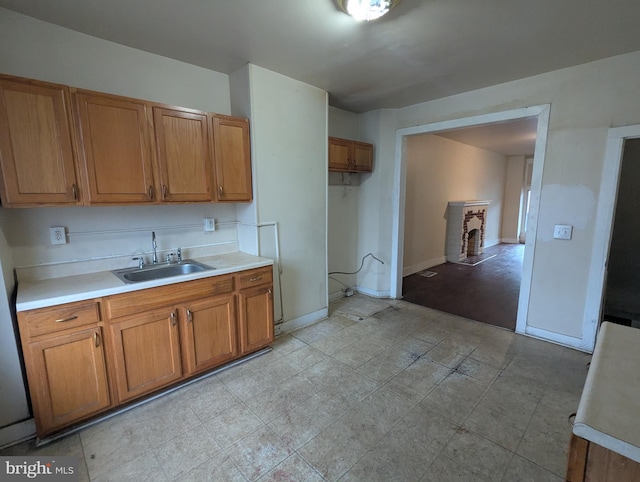 525 N Robinson St, Baltimore, MD 21205 - kitchen featuring a sink, brown cabinetry, light countertops, and baseboards
