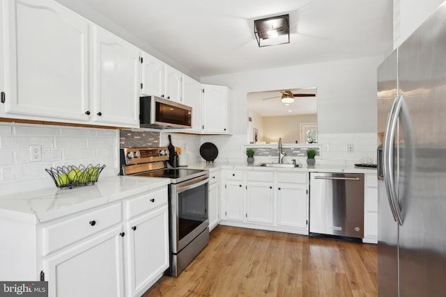 835 Sabina Cir, Bear, DE 19701 - kitchen with appliances with stainless steel finishes, a sink, decorative backsplash, white cabinetry, and a ceiling fan