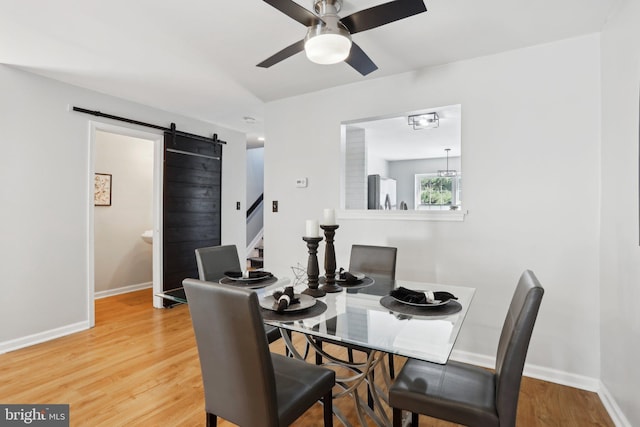835 Sabina Cir, Bear, DE 19701 - dining space featuring a barn door, a ceiling fan, baseboards, and light wood-style flooring