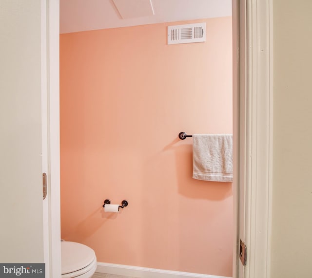 bathroom with toilet and baseboards