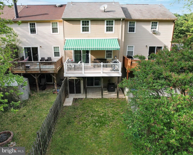 rear view of property featuring a wooden deck and a patio area