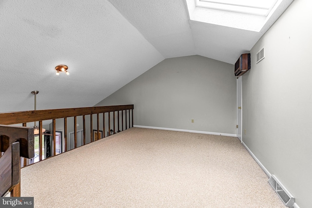 28 Chatham Ct, Dover, DE 19901 - additional living space with a skylight, vaulted ceiling, carpet, a textured ceiling, and baseboards