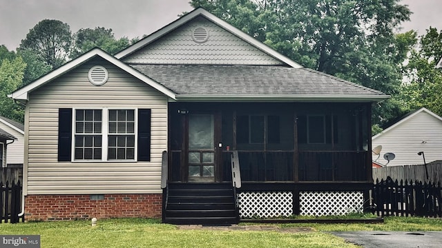 view of front facade with roof with shingles, crawl space, and a sunroom