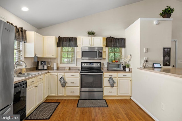 309 6th St, Colonial Beach, VA 22443 - kitchen featuring stainless steel appliances, a sink, lofted ceiling, light wood-type flooring, and light countertops