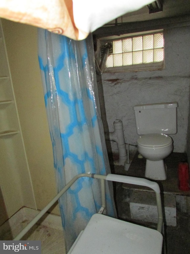 full bath featuring a shower with shower curtain and toilet