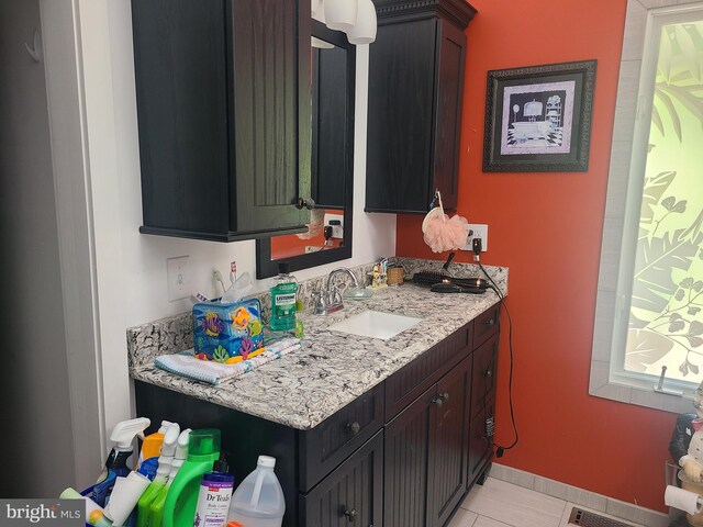 bathroom featuring vanity, tile patterned floors, and baseboards