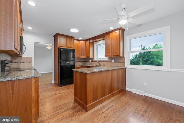 2518 Reynolds Ave, Claymont, DE 19703 - kitchen featuring black refrigerator with ice dispenser, backsplash, a peninsula, stainless steel range with electric cooktop, and baseboards