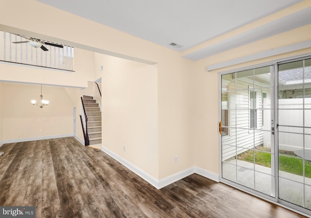 unfurnished living room featuring stairs, healthy amount of natural light, and wood finished floors