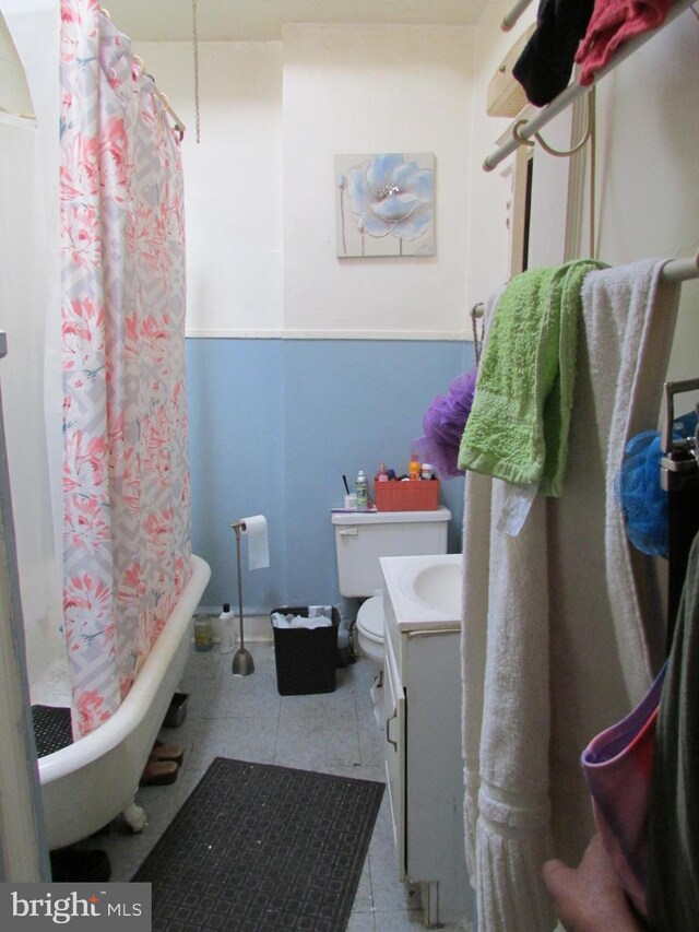 524 W Tabor Rd, Philadelphia, PA 19120 - bathroom featuring vanity, toilet, a shower with curtain, tile patterned flooring, and a tub to relax in