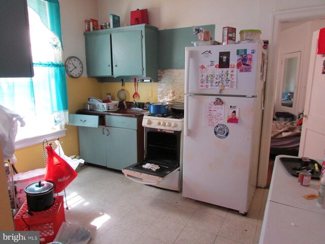 524 W Tabor Rd, Philadelphia, PA 19120 - kitchen featuring white appliances, decorative backsplash, and light tile patterned floors
