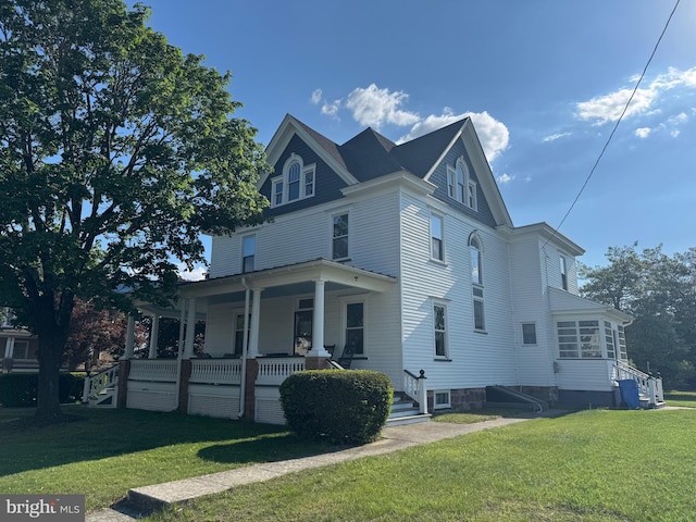 view of property exterior featuring covered porch and a lawn