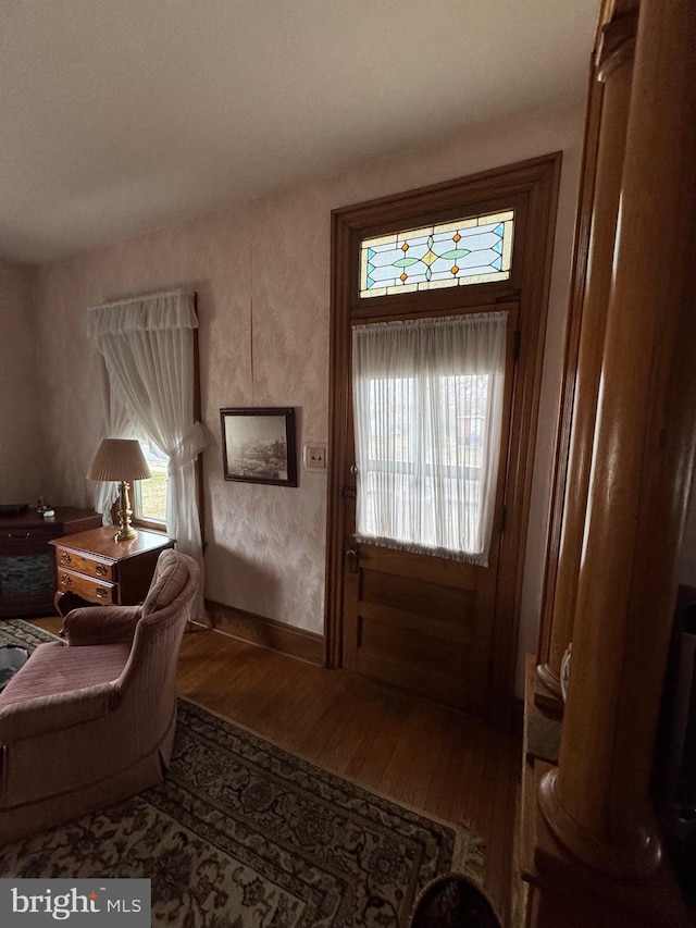 doorway to outside with wood finished floors and baseboards