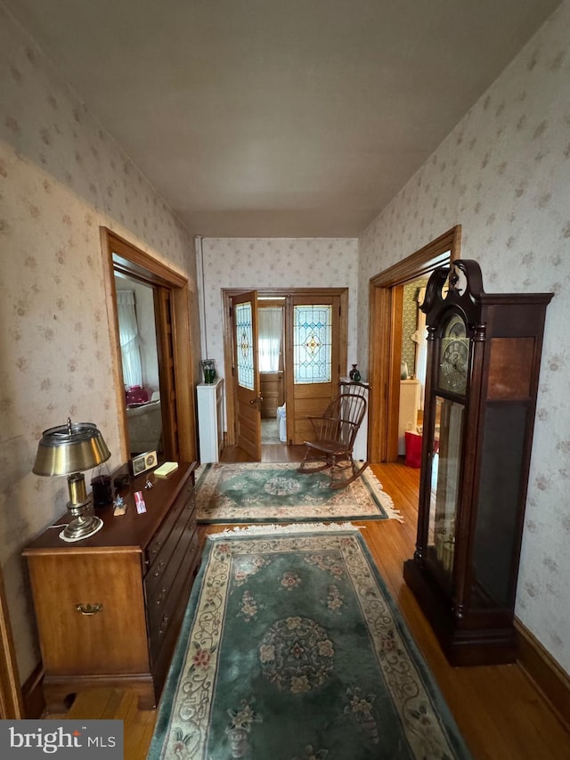 hallway featuring wallpapered walls and wood finished floors