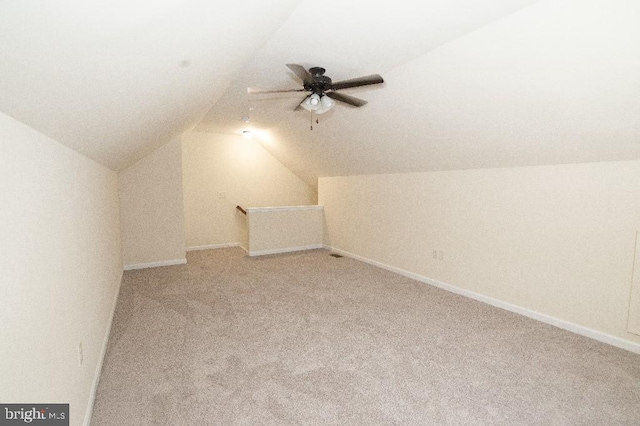 bonus room featuring vaulted ceiling, light carpet, ceiling fan, and baseboards