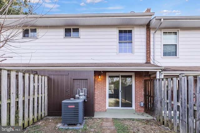 312 E Cornell Dr, Sterling, VA 20164 - rear view of property featuring central AC, brick siding, and a fenced backyard