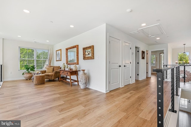 corridor featuring attic access, light wood finished floors, an upstairs landing, baseboards, and recessed lighting