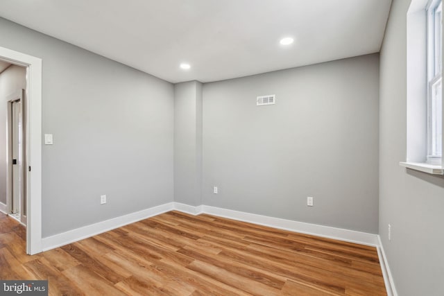 unfurnished room with light wood finished floors, baseboards, and recessed lighting