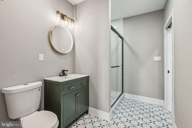 full bathroom with tile patterned floors, a shower stall, toilet, vanity, and baseboards