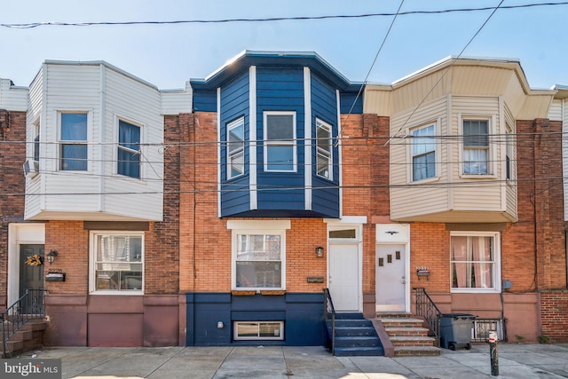 townhome / multi-family property with entry steps and brick siding