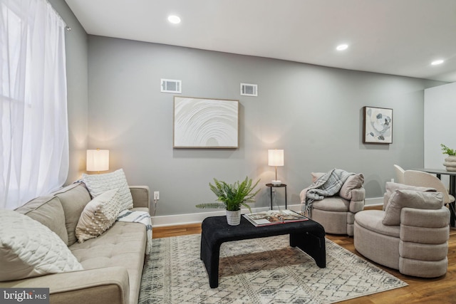 living area with baseboards, recessed lighting, and wood finished floors