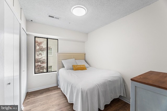 210 Trimper Ave Unit 8, Ocean City, MD 21842 - bedroom with wood finished floors, a textured ceiling, a closet, and baseboards