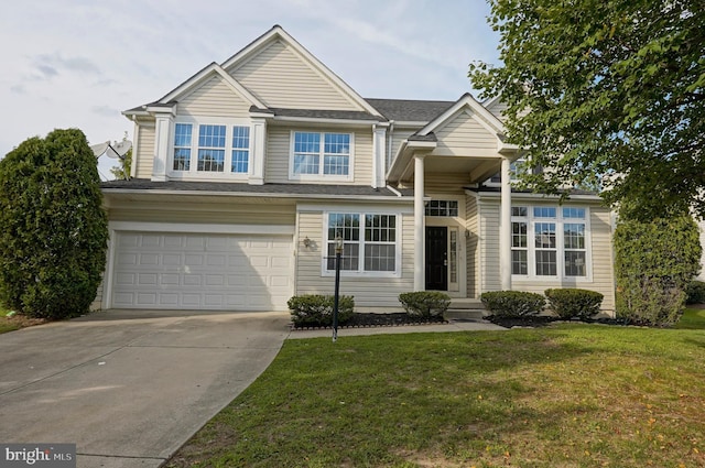 view of front of home featuring driveway, an attached garage, and a front yard