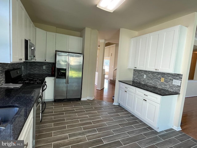kitchen featuring stainless steel appliances, dark wood-style flooring, white cabinetry, and decorative backsplash