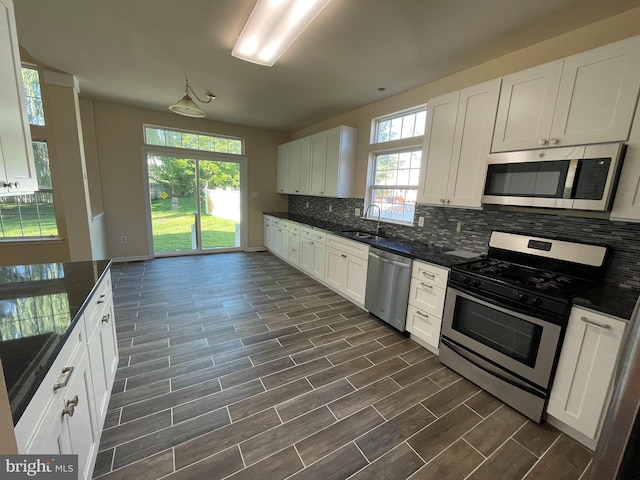 kitchen featuring appliances with stainless steel finishes, a sink, plenty of natural light, and decorative backsplash
