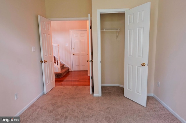 unfurnished bedroom with carpet flooring, a closet, and baseboards