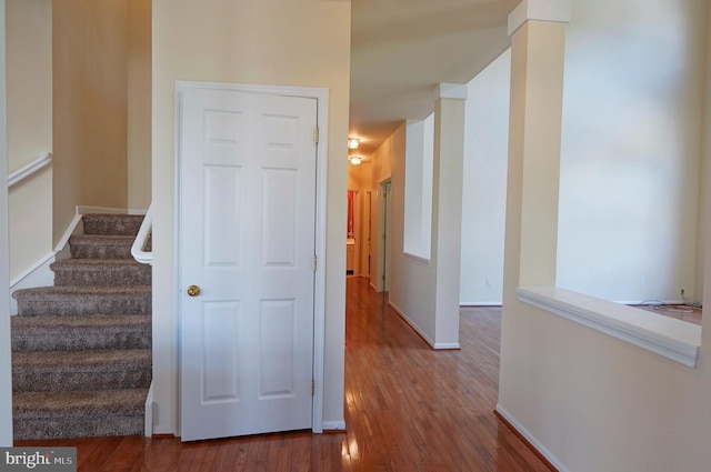 stairway with wood finished floors and baseboards