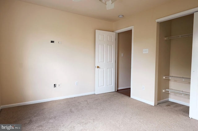 unfurnished bedroom with carpet flooring, baseboards, and a closet