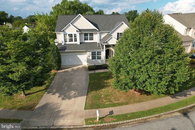 traditional-style home featuring driveway, a garage, a shingled roof, and brick siding