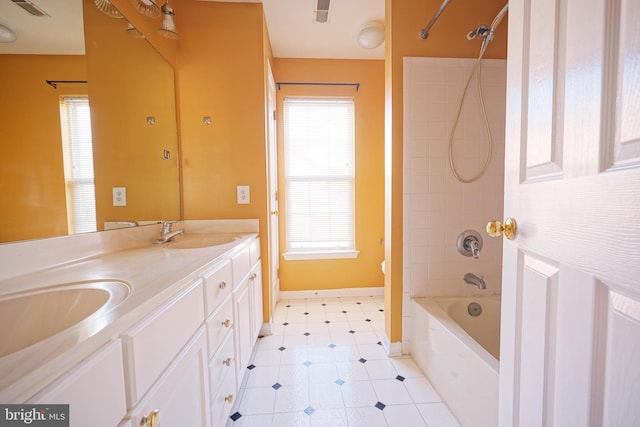 bathroom featuring toilet, double vanity, tile patterned flooring, shower / bathtub combination, and baseboards