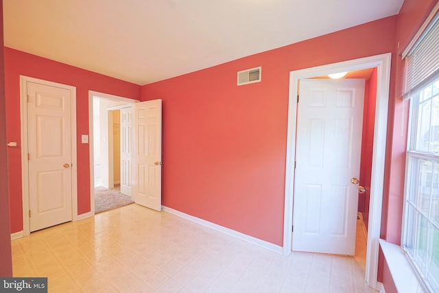 unfurnished room featuring light floors and baseboards