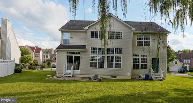 back of property with entry steps and a lawn